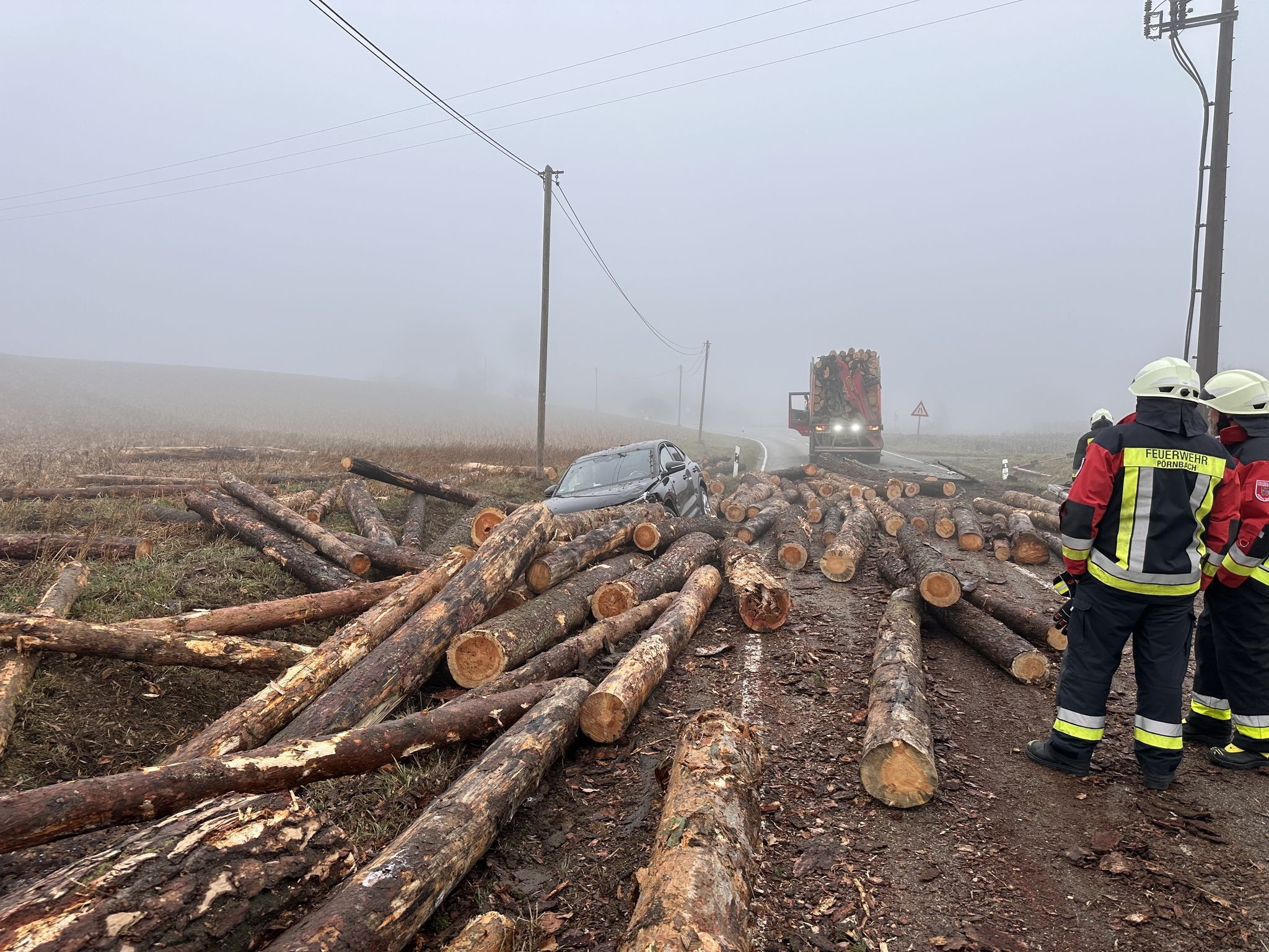 Holzstämme fallen von Laster auf Auto – Insassen unverletzt